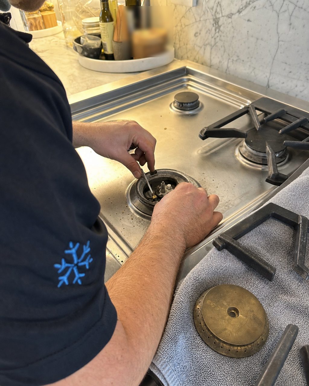 Technician servicing a Wolf sealed burner and spark igniter