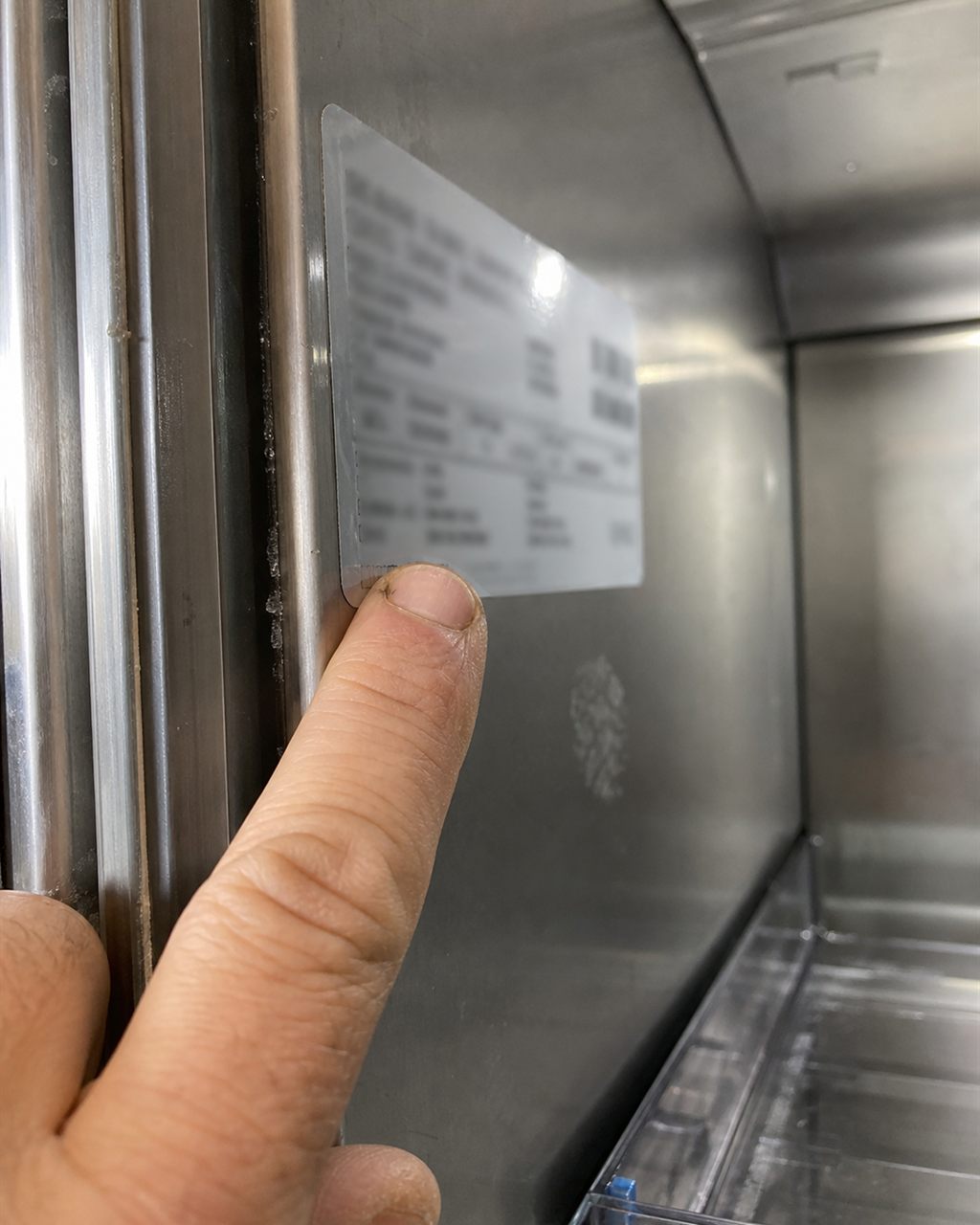 Technician checking a Sub-Zero model and serial tag