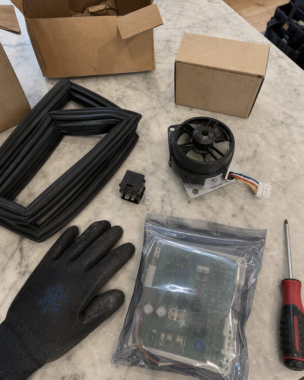 Genuine OEM Sub-Zero parts laid out on a counter